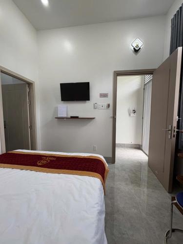 a hotel room with a bed and a tv on the wall at THIÊN HÀ Motel in Soc Trang