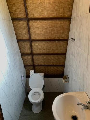 a small bathroom with a toilet and a sink at Giri Garden Sunset Glamping in Gitgit