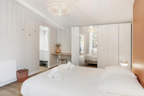 a white bedroom with two beds and a mirror at Belle maison 8 personnes à 600m de la plage avec parking privé in Dinard