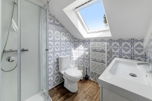 a bathroom with a toilet and a sink and a window at Belle maison 8 personnes à 600m de la plage avec parking privé in Dinard