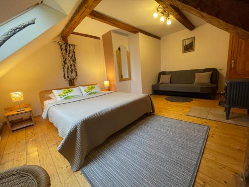 a bedroom with a large bed and a couch at Viesu nams "Vijās" in Degumuiža