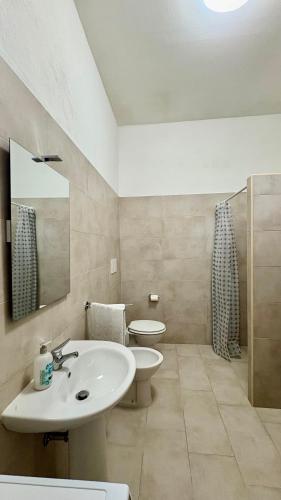 a bathroom with a sink and a toilet and a mirror at B&B Martina in Martignano