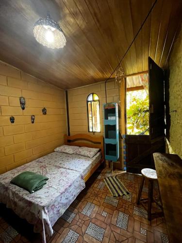 a bedroom with a bed in a room with a window at Chalés Recanto da Aldeia in Itanhaém