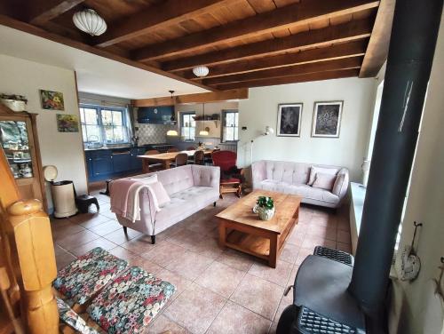 a living room with two couches and a table at Holiday home bos en heide in Otterlo