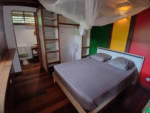 a bedroom with a bed and a colorful wall at Lodge Kunawalu in Roura