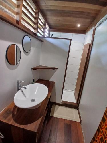 a bathroom with a sink and a mirror at Lodge Kunawalu in Roura