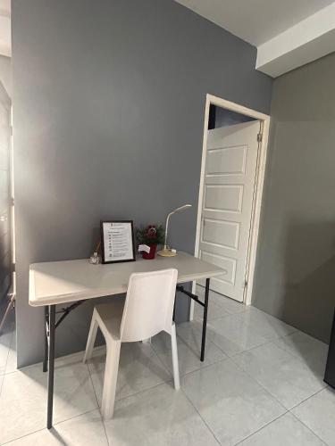 a table with a white chair and a white door at Dories Residences - Unit 6 in Pozorrubio