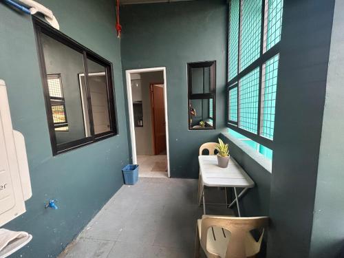 a room with a blue wall with a table and windows at Dories Residences - Unit 6 in Pozorrubio