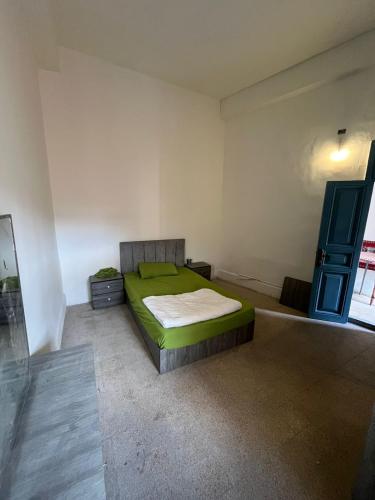 a bedroom with a green bed in a room at The Blue House in Amman