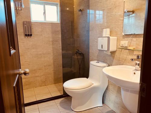 a bathroom with a toilet and a sink at Pet Truelove in Hengchun South Gate