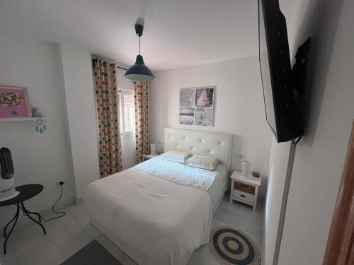 a bedroom with a bed and a flat screen tv at Malaga Mijas Costa Pool Nuevo Piso in Mijas Costa