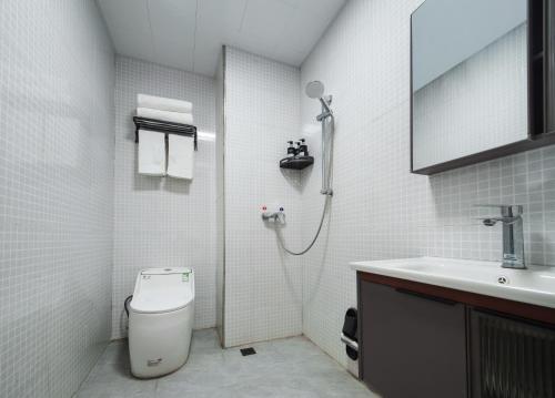 a bathroom with a shower and a toilet and a sink at Astria Moruo Retreat in Xinglong