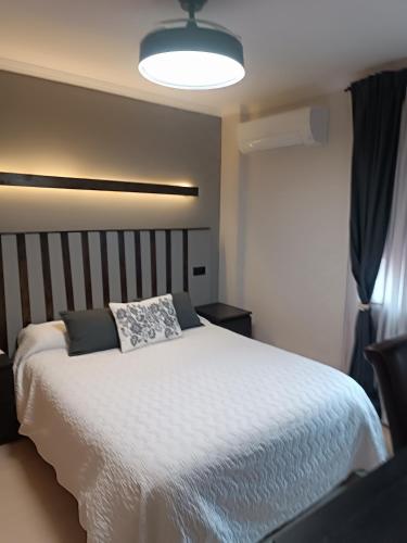 a bedroom with a white bed and a light at Motel Mary in Jávea