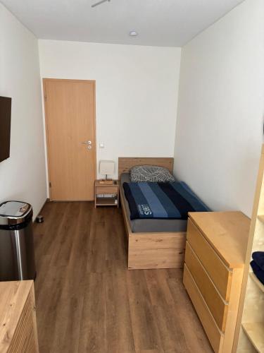 a small bedroom with a bed and a wooden floor at Einzelzimmer in ruhiger Lage --- Check-In mit Schlüsselkasten in Meppen