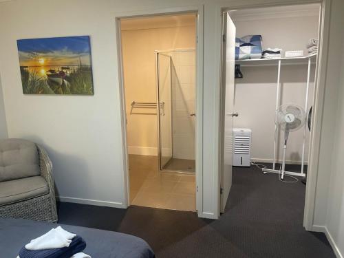 a room with a shower and a bed and a chair at Accomodation at Lavington in Lavington