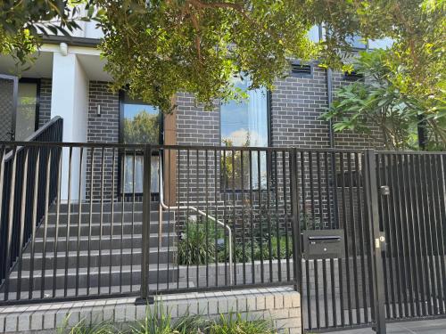 a black fence in front of a house at 安静的住宅区 4个卧室 2个卫生间 临近悉尼机场 市区 海滩 in Sydney