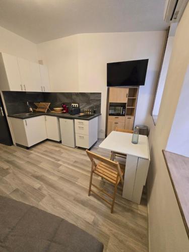 Studio Vacances super équipé في كاربينترا: مطبخ به طاولة بيضاء وطاولة وكرسي