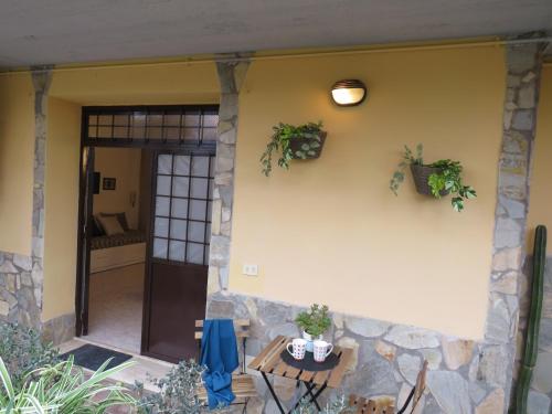 a front door of a house with a table and plants at Civico 55 in Casale Torre San Giovanni