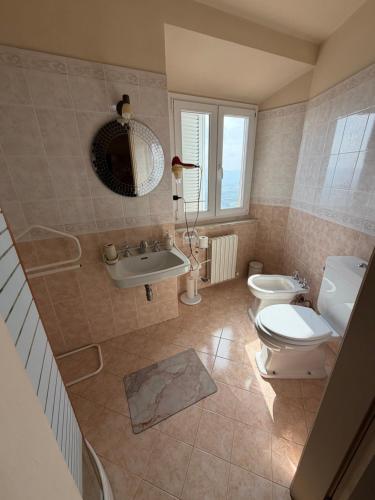 a bathroom with a toilet and a sink and a mirror at B&B Falconi in Fermo