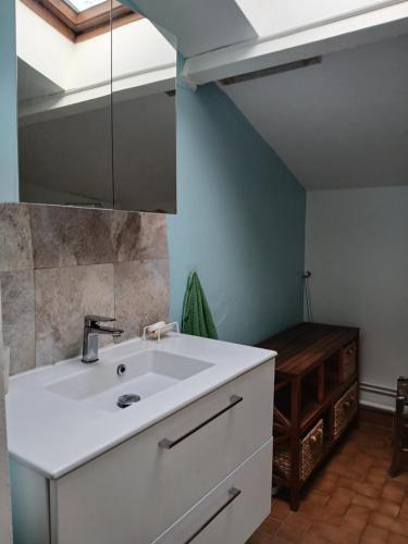 a bathroom with a white sink and a table at Boningal in Moissac