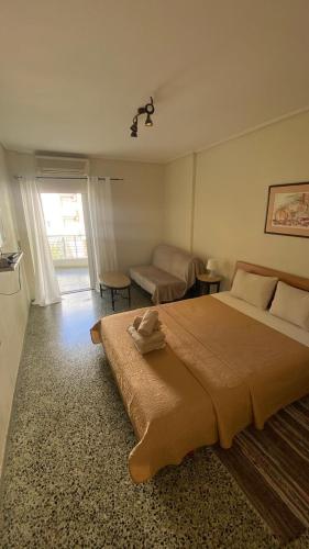 a bedroom with a large bed and a living room at Loutraki Suites in Loutraki