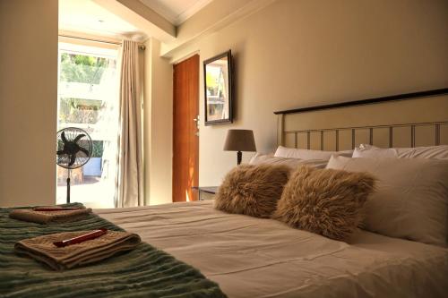 a bedroom with a bed with two towels on it at Vitry Country Estate in Gqeberha