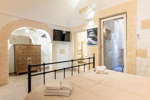 a bedroom with a bed and a bathroom with a shower at Casa Roma 78 Traditional Stone House in Monopoli Center in Monopoli