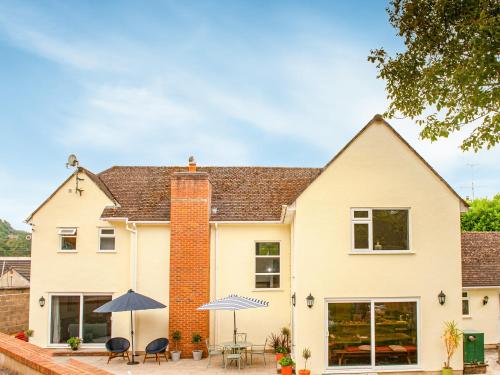 a white house with tables and umbrellas at Brooklands in Uplyme