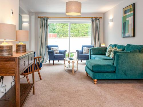 a living room with a green couch and chairs at Brooklands in Uplyme