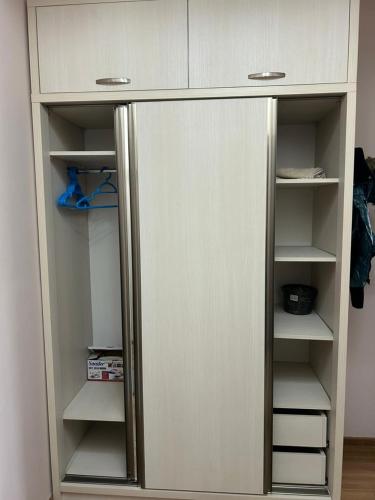 a white cupboard with doors and shelves in a room at Hotel Tamo in Tsqaltubo