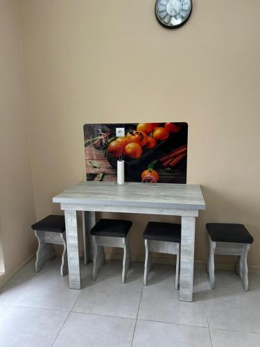 a table with four chairs and a picture of fruit at Hotel Tamo in Tsqaltubo