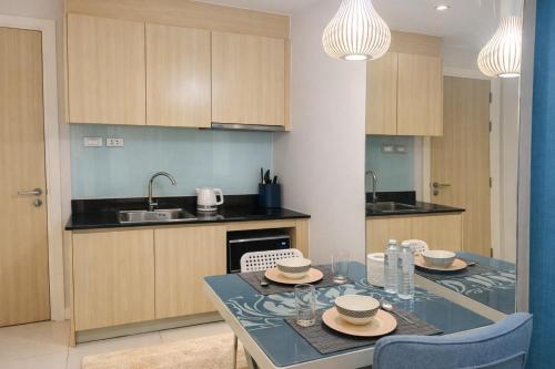 a kitchen with a dining table with two chairs at Caribbean Resort Pool Apartments Pattaya Near Bus Terminal in Pattaya South