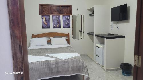 a small bedroom with a bed and a tv at Pousada irmãos Calixto in Portalegre