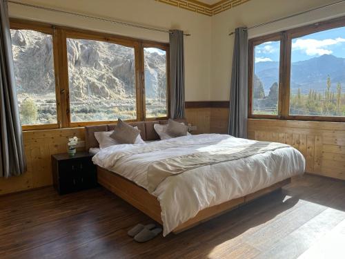 a bedroom with a large bed with large windows at Blue Yak Resort in She