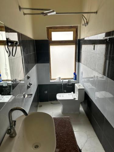 a bathroom with a sink and a toilet and a window at Blue Yak Resort in She