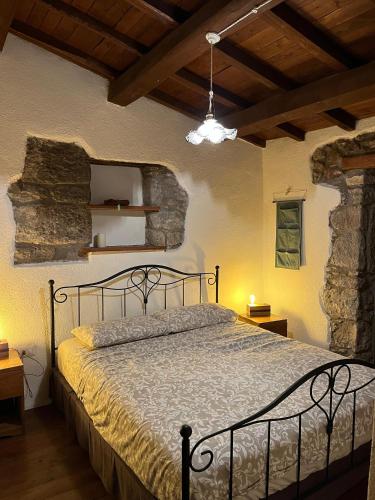 a bedroom with a bed and a stone wall at The Templars Guesthouse in Santu Lussurgiu