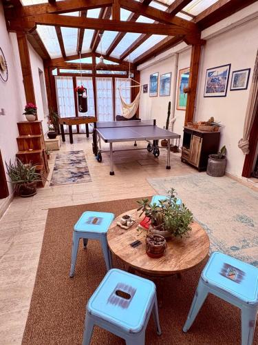 a room with a ping pong table and blue stools at Casetta La Pera in Perarolo