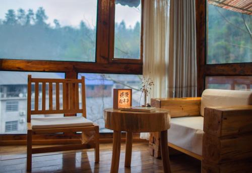 a bedroom with a bed and a chair and a table at Astria Moruo Retreat in Xinglong