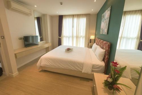 a hotel room with two beds and a television at Caribbean Resort Pool Apartments Pattaya Near Bus Terminal in Pattaya South
