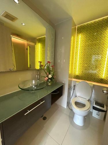 a bathroom with a toilet and a sink with a mirror at Caribbean Resort Pool Apartments Pattaya Near Bus Terminal in Pattaya South