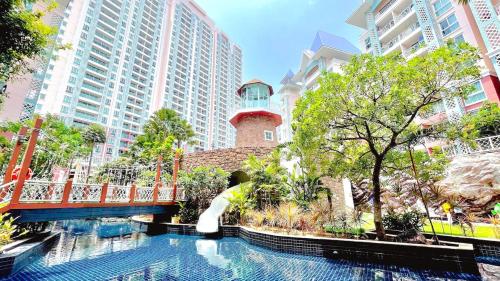 a bridge over a pool in a city with buildings at Caribbean Resort Pool Apartments Pattaya Near Bus Terminal in Pattaya South