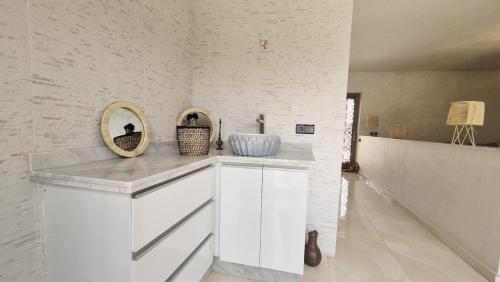 a white kitchen with a counter with a mirror at Modern Design Villa Private Pool Marrakech in Marrakesh