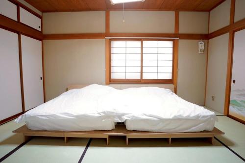 a large bed in a room with a window at リトリート奥入瀬屋 in Towada