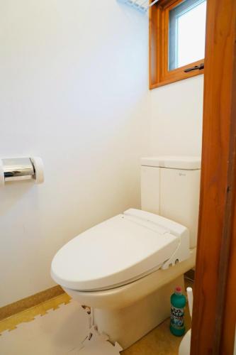 a white toilet in a bathroom with a window at リトリート奥入瀬屋 in Towada
