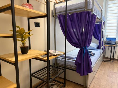 ein Zimmer mit Etagenbetten und einem lila Vorhang in der Unterkunft Kust Hostel in Kiew