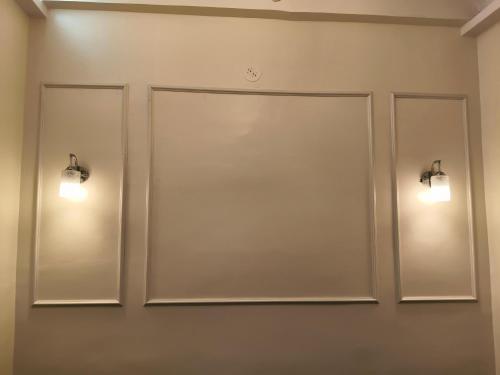 two mirrors on a wall with lights on it at Hotel Atithi Lodging in Pimpalgaon