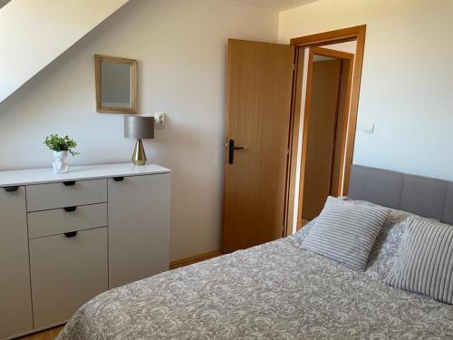 a bedroom with a bed and a dresser and a mirror at Evergreen Sokolina in Rača
