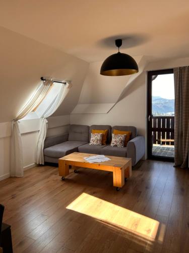 a living room with a couch and a coffee table at Apartamenty na Rycerskiej in Czorsztyn