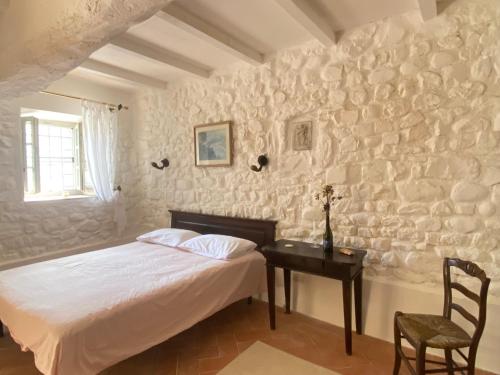 a bedroom with a bed and a table with a chair at Casa Rosmarino Malgrate in Filetto