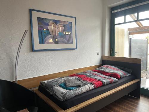 a bed in a room with a picture on the wall at Pension Hammoor in Hammoor